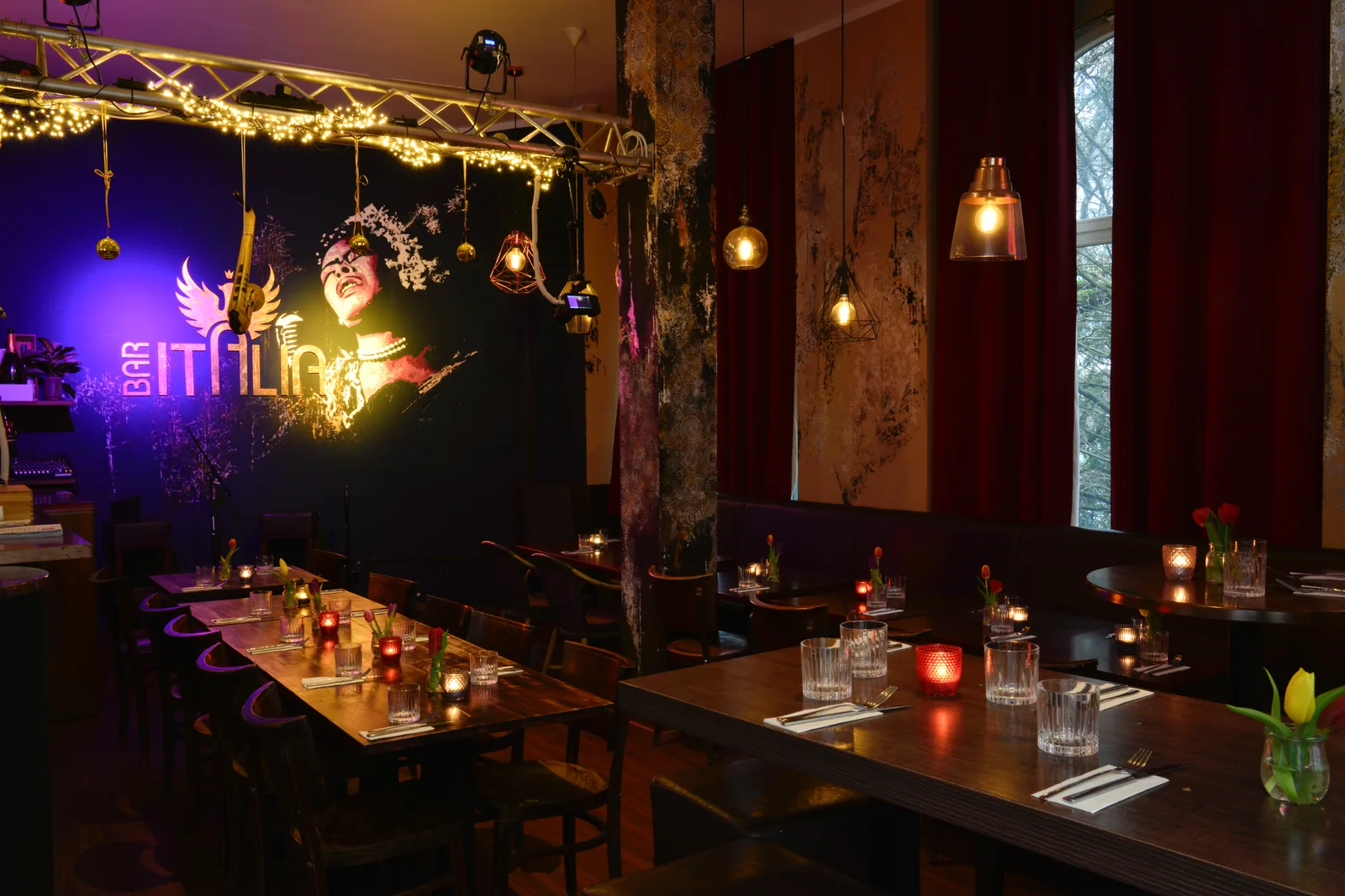 Leerer Gastraum der Bar Italia mit gedeckten Tischen und Lichterpergola