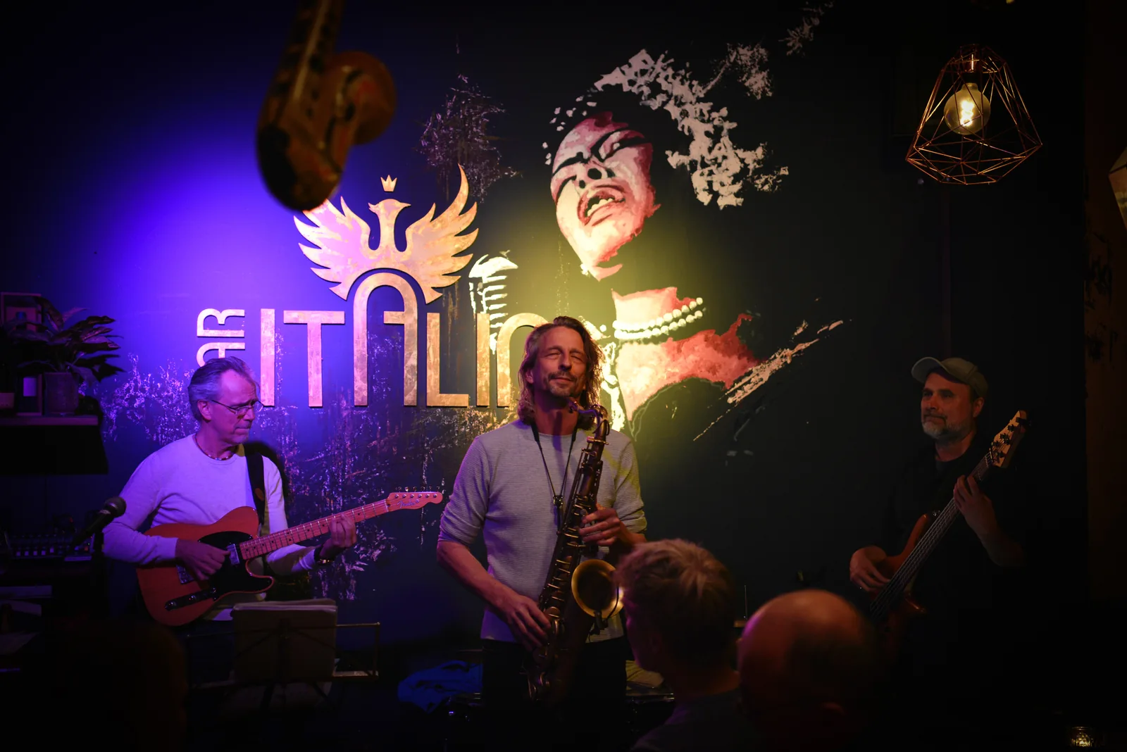 Band mit Saxofon auf der Bühne der Bar Italia, Publikum im Vordergrund